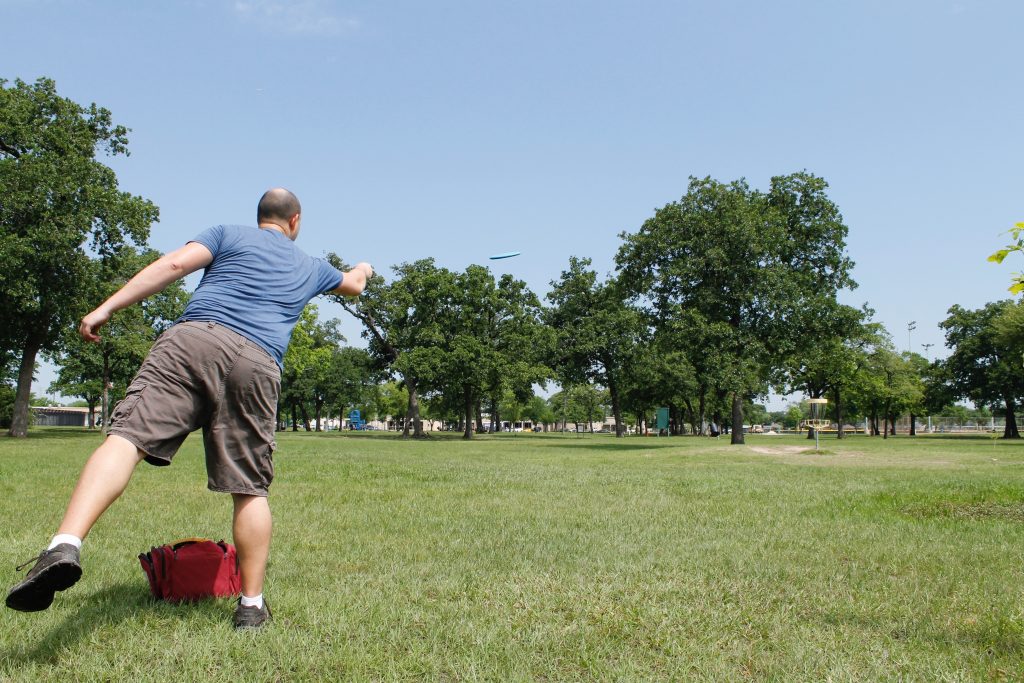 Homem jogando frisbee no parque