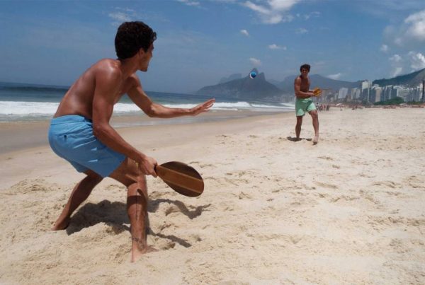 Meninos jogando frescobol na praia