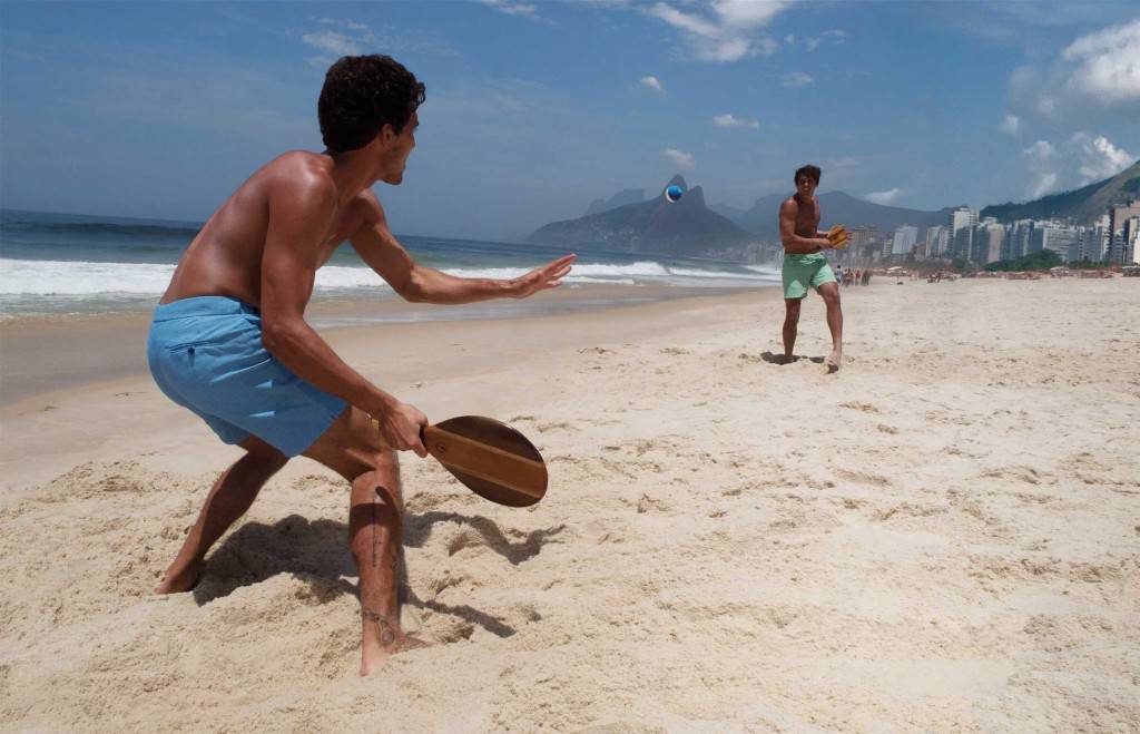 Meninos jogando frescobol na praia